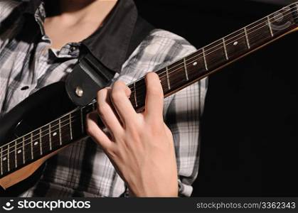 The guitarist plays on a guitar shooting closeup