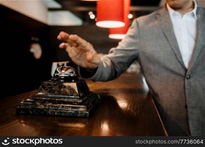 the guy clicks on the bell at the reception of the hotel