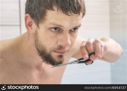 The guy is a scissors with a beard on his chin