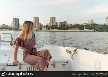 The guy jumps into the water from the boat. A beautiful girl is watching him. Khabarovsk, Russia - Jul 19, 2019: The guy jumps into the water from the boat. A beautiful girl is watching him.