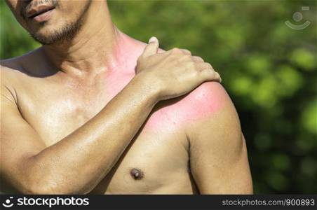 The hand grips the shoulder that inflammation from a sports injury.