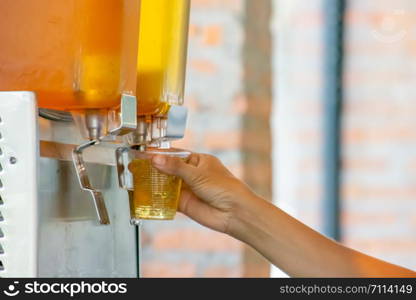 The hand holding the cup plastic flush tea from Juice Dispensor.