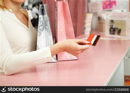 The hand holds a credit card against a counter