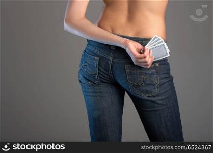 The hand holds cards in front of female back in jeans. Good luck!