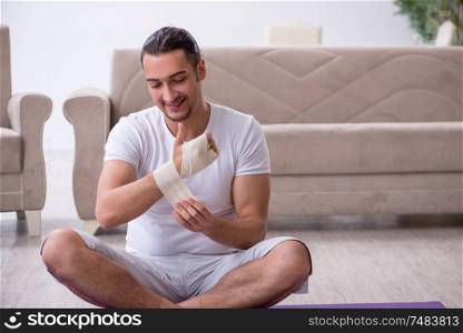 The hand injured man doing exercises at home. Hand injured man doing exercises at home