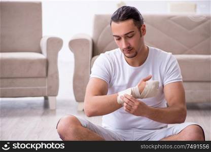 The hand injured man doing exercises at home. Hand injured man doing exercises at home
