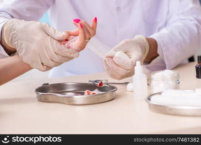 The hand injured woman visiting doctor traumatologist . Hand injured woman visiting doctor traumatologist
