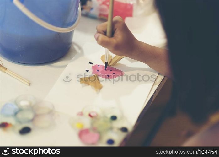The hand of a child drawing a paintbrush.