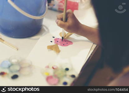 The hand of a child drawing a paintbrush.