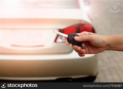 The hand of a woman holding a car key to be submitted to the driver of this car.