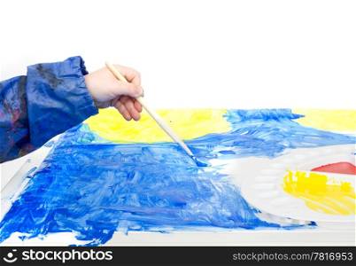 The hand of a young child holding a brush with blue poster paint