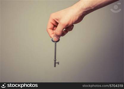 The hand of a young man is holding a key