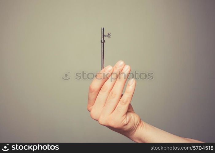 The hand of a young man is holding a key