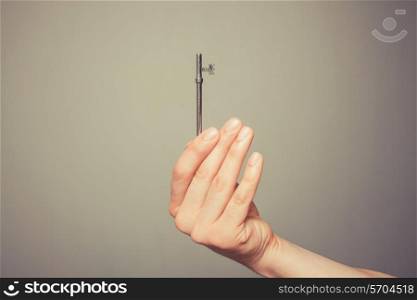 The hand of a young man is holding a key