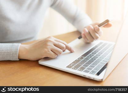 The hand of Asian women are using smartphone and computer in the office. Young women are using phones in social networks.