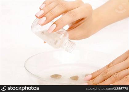 The hand pours salts in a salt bath for hands