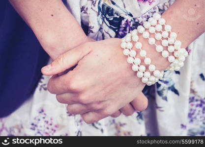 the hands of a young woman wearing bracelets