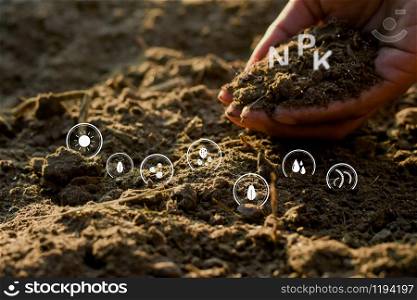 The hands of men are holding the soil rich in all the elements needed to grow plants and have digital icons included.