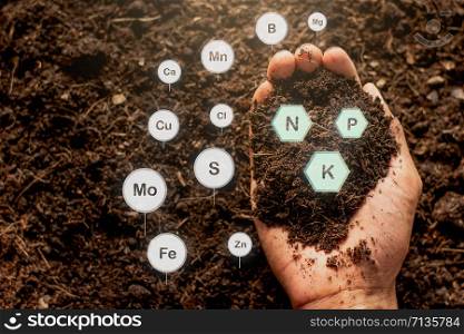 The hands of men are holding the soil rich in all the elements needed to grow plants and have digital icons included.