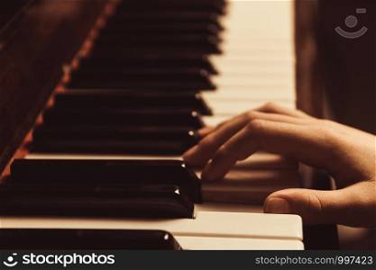the hands on the piano keys. Photo piano in retro style.. the hands on the piano keys. Photo piano in retro style
