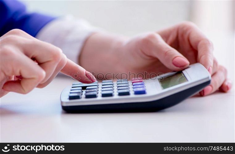 The hands working on accounting calculator calculating profit. Hands working on accounting calculator calculating profit