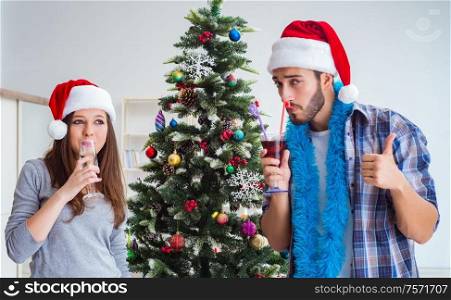 The happy boyfriend and girlfriend drinking champagne on christmas. Happy boyfriend and girlfriend drinking champagne on christmas