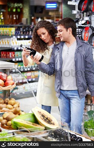 The happy couple chooses a wine bottle in shop
