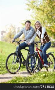 The happy couple on bicycles in the park