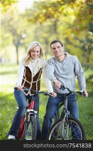 The happy couple on bicycles in the park