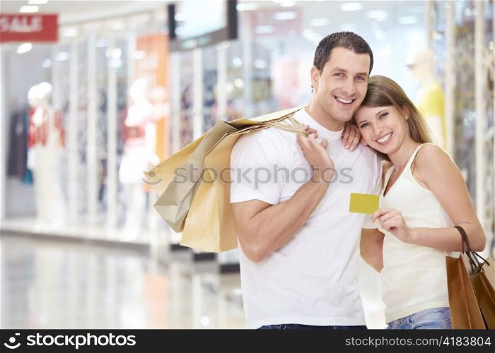 The happy couple with a credit card and shopping at the store