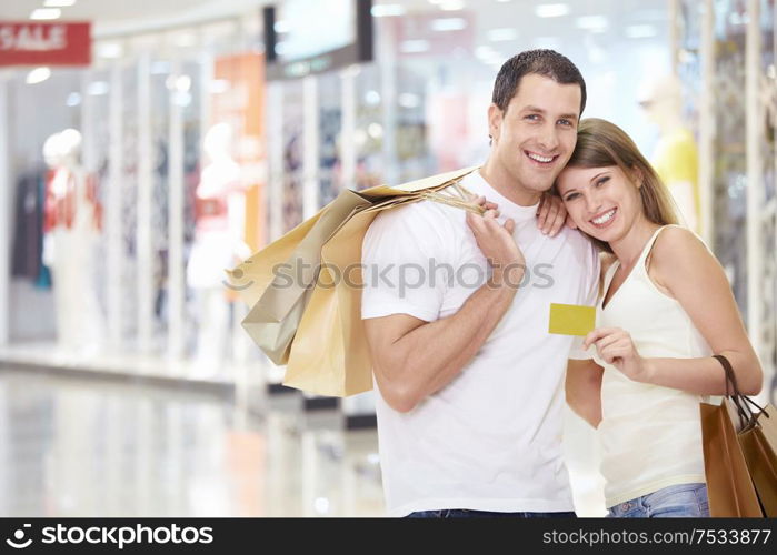 The happy couple with a credit card and shopping at the store