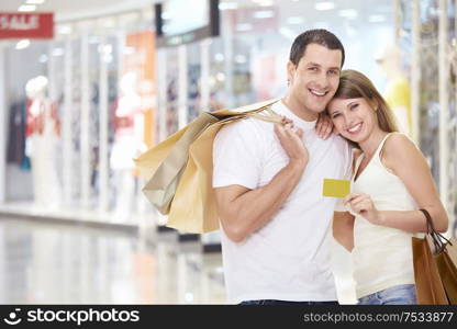 The happy couple with a credit card and shopping at the store