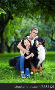 The happy couple with a dog in the park