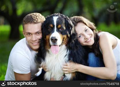 The happy couple with a dog in the park