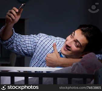 The happy dad looking after newborn baby at night. Happy dad looking after newborn baby at night