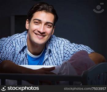 The happy dad looking after newborn baby at night. Happy dad looking after newborn baby at night