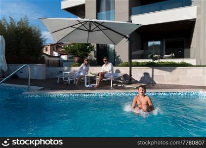 The happy family enjoys vacation in a luxury house with a pool. The senior couple spends time with their son during the vacation. Selective focus. High-quality photo. Happy family enjoys vacation in a luxury house with pool. Senior couple spends time with their son during the vacation. Selective focus 