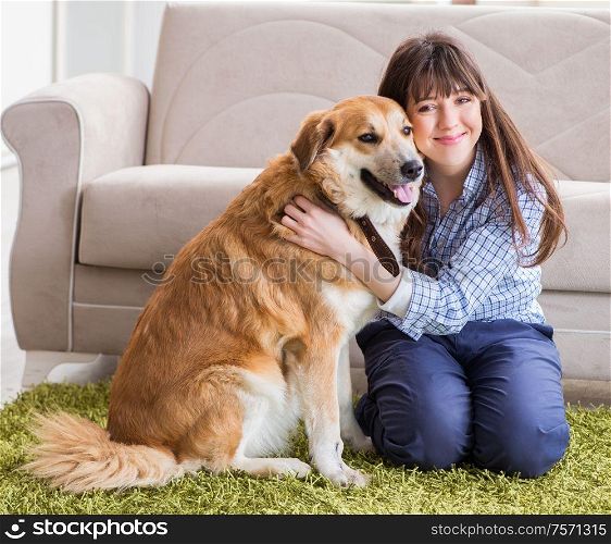The happy woman dog owner at home with golden retriever. Happy woman dog owner at home with golden retriever