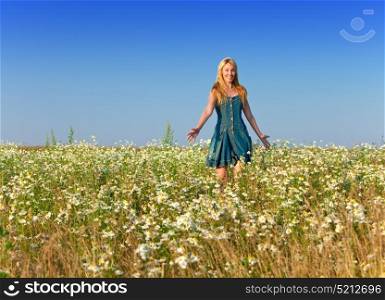 The happy young woman in the field of camomiles