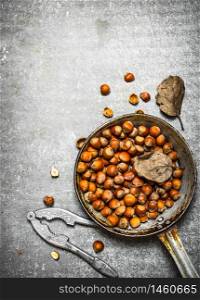 The hazelnuts in an old pan. On the stone table.. The hazelnuts in an old pan.