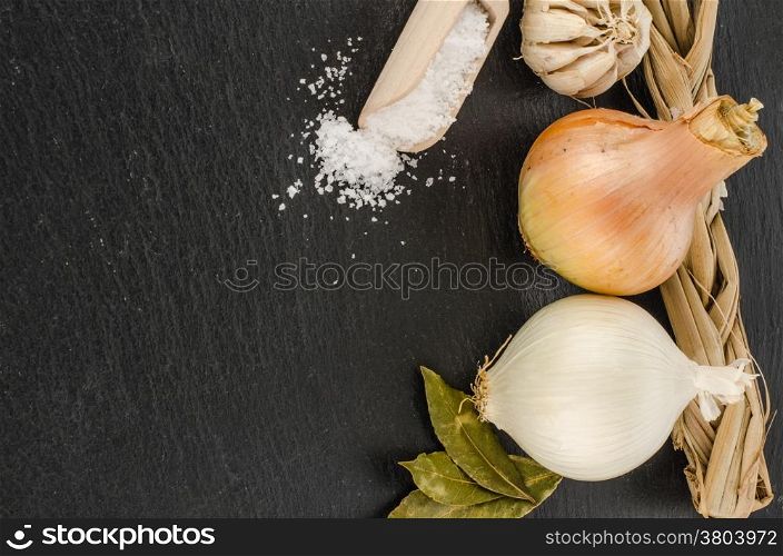 The head of garlic, onions, salt on chalkboard