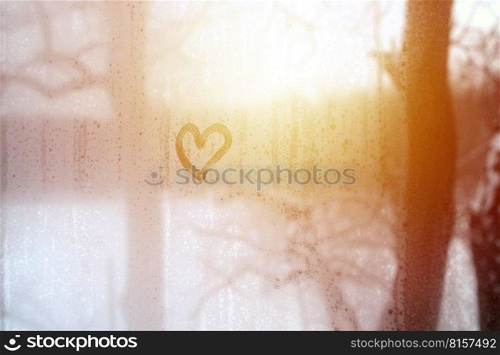 The heart is painted on the misted glass in the winter