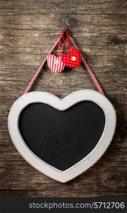 The heart shape chalkboard over old wooden background