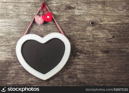 The heart shape chalkboard over old wooden background. The heart shape chalkboard