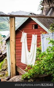 The Helleren houses in Jossingfjord along road 44 between Egersund and Flekkefjord, Sokndal municipality, Norway. Detailed view clothing hanging on rope. The Helleren houses in Jossingfjord, Norway