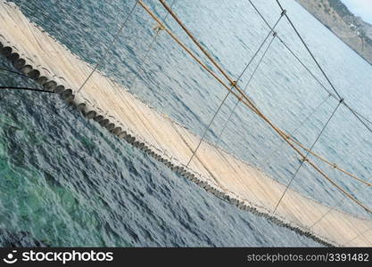 The hinged bridge. Above the sea to island on which it is located by cafe