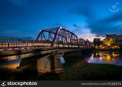 The historical iron bridge at Chiangmai city skyline at Ping river at dusk. Chiangmai , Thaland. Long exposure photograph.. The historical iron bridge at Chiangmai city skyline.