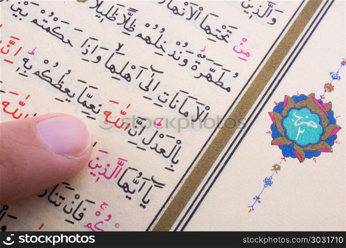 The Holy Quran. Hand holding The Holy Quran on a white background