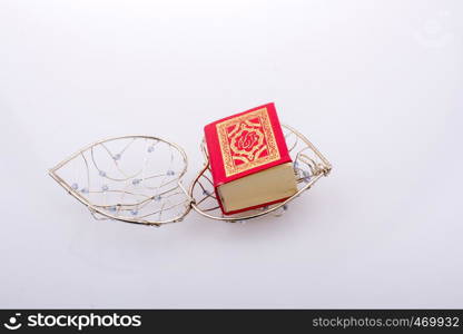 The Holy Quran in mini size in a heart shaped cage