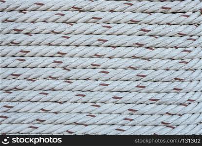 The horizontal pattern of the rope tied on a wooden port pole in close up view.